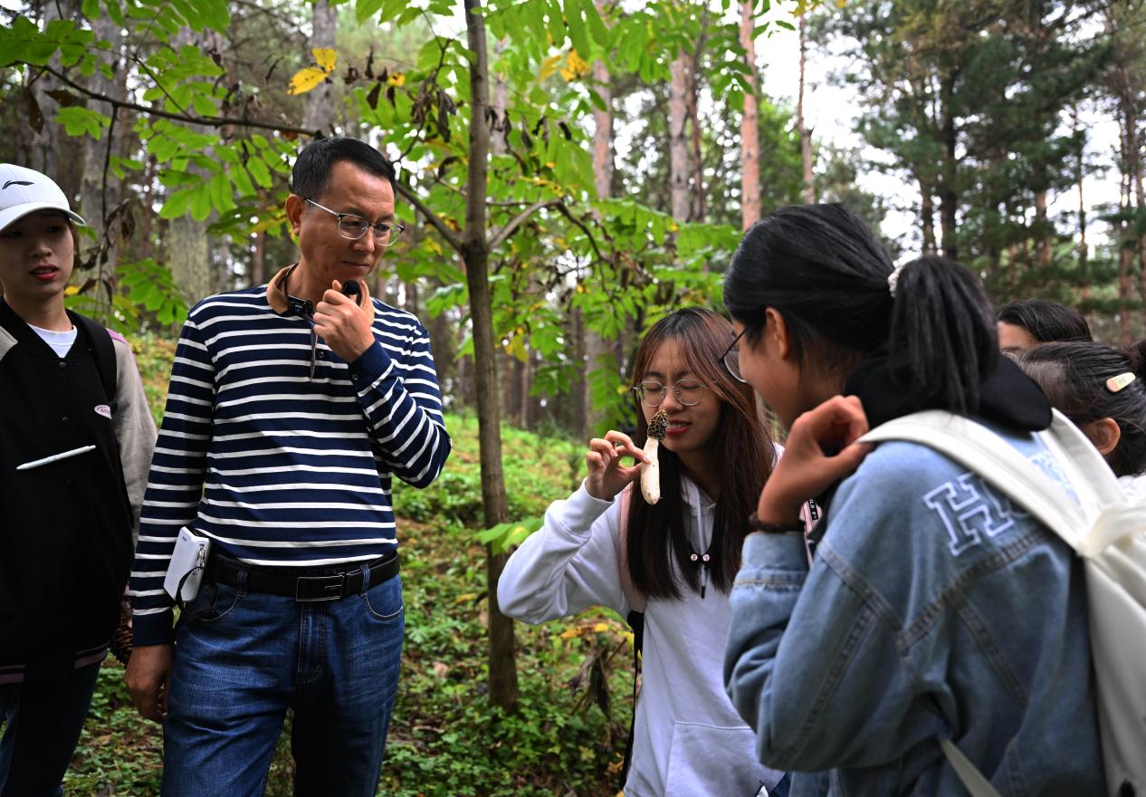 王占斌老師給同學(xué)們講解辨識(shí)蘑菇。（學(xué)校供圖）.jpg