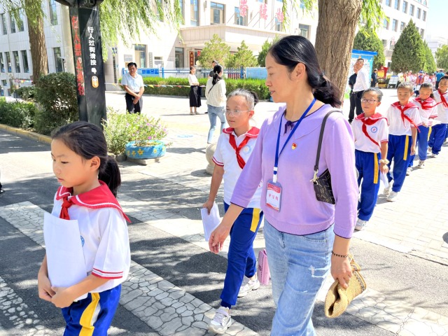 02 臨澤縣城關(guān)小學“紅燭先鋒”護學崗教師護送學生放學。謝靜 攝.jpg