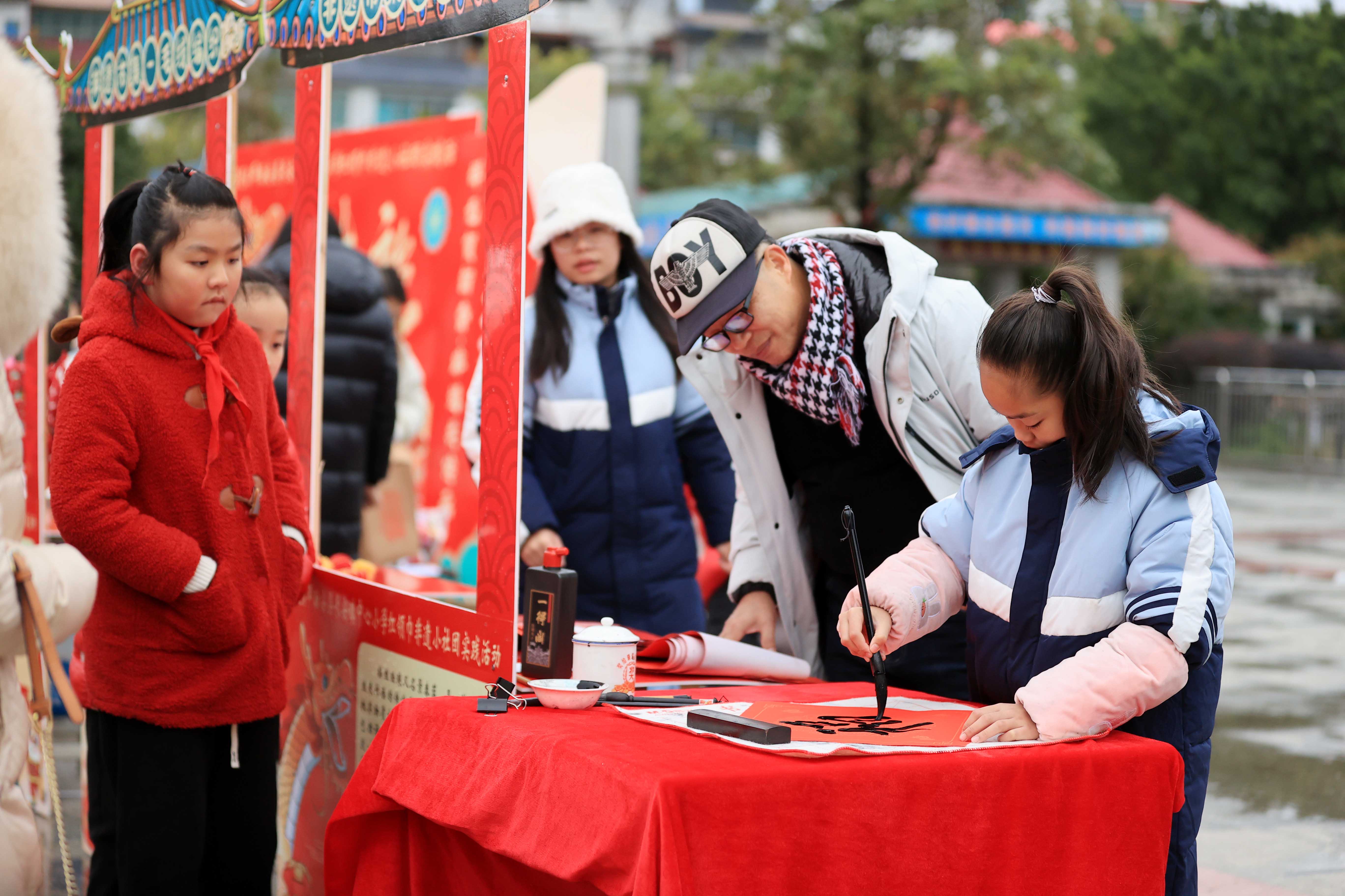 圖10：1月20日，在廣西柳州市融安縣長安廣場，一名小學(xué)生在書寫福字，準(zhǔn)備贈(zèng)送市民。（譚凱興 攝）.JPG
