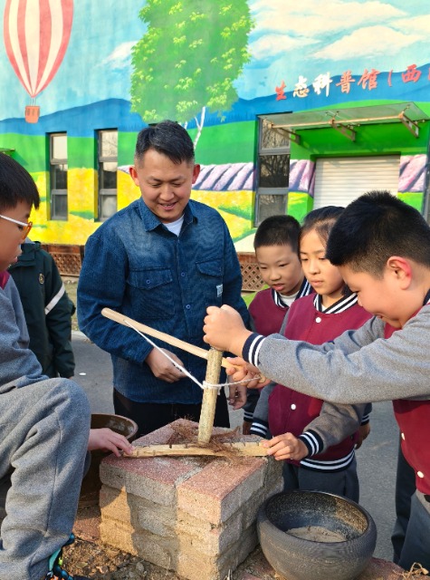 沈撫育才實驗學(xué)校老師給學(xué)生們講解鉆木取火的科學(xué)原理.jpg 沈撫育才實驗學(xué)校老師給學(xué)生們講解鉆木取火的科學(xué)原理.jpg