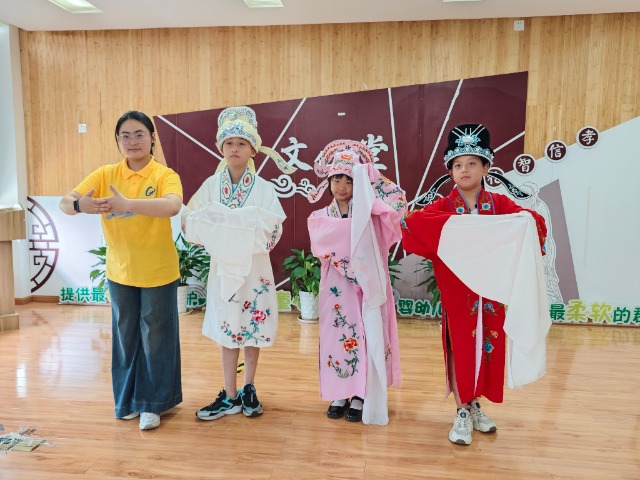 寧波職業(yè)技術(shù)大學(xué)“拾夢非遺”服務(wù)隊(duì)教小朋友們學(xué)唱傳統(tǒng)戲曲 學(xué)校供圖.jpg