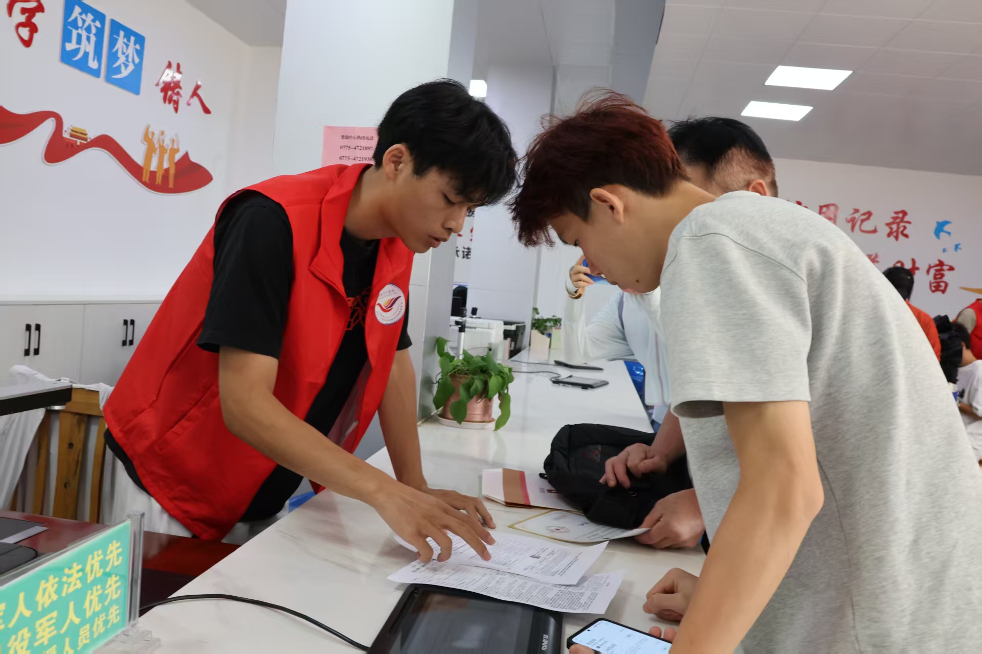 覃塘區(qū)：志愿者指引前來辦理貸款業(yè)務(wù)的學(xué)生.jpg