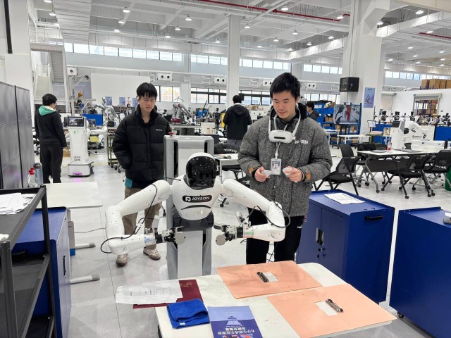 浙江工商職業(yè)技術(shù)學(xué)院“普智未來”訂單班學(xué)生在調(diào)試機器人 學(xué)校供圖.png